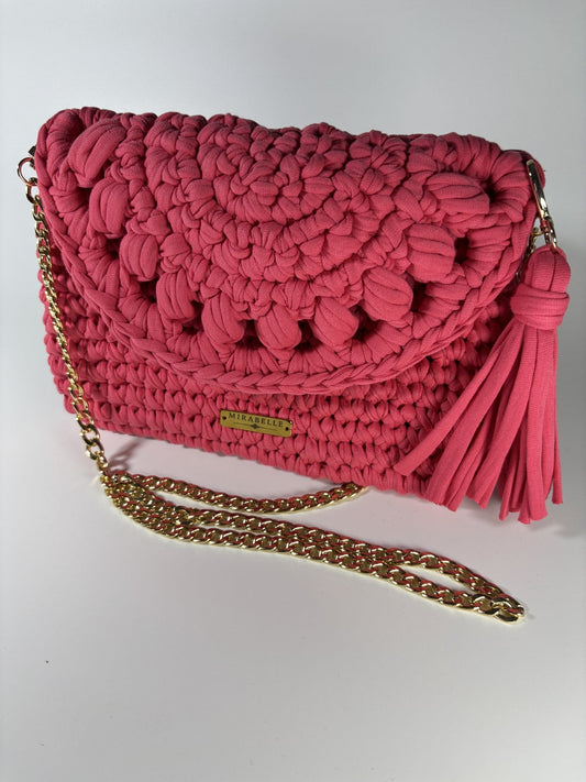 Pochette écaille corail, trois quarts avec plaque logo