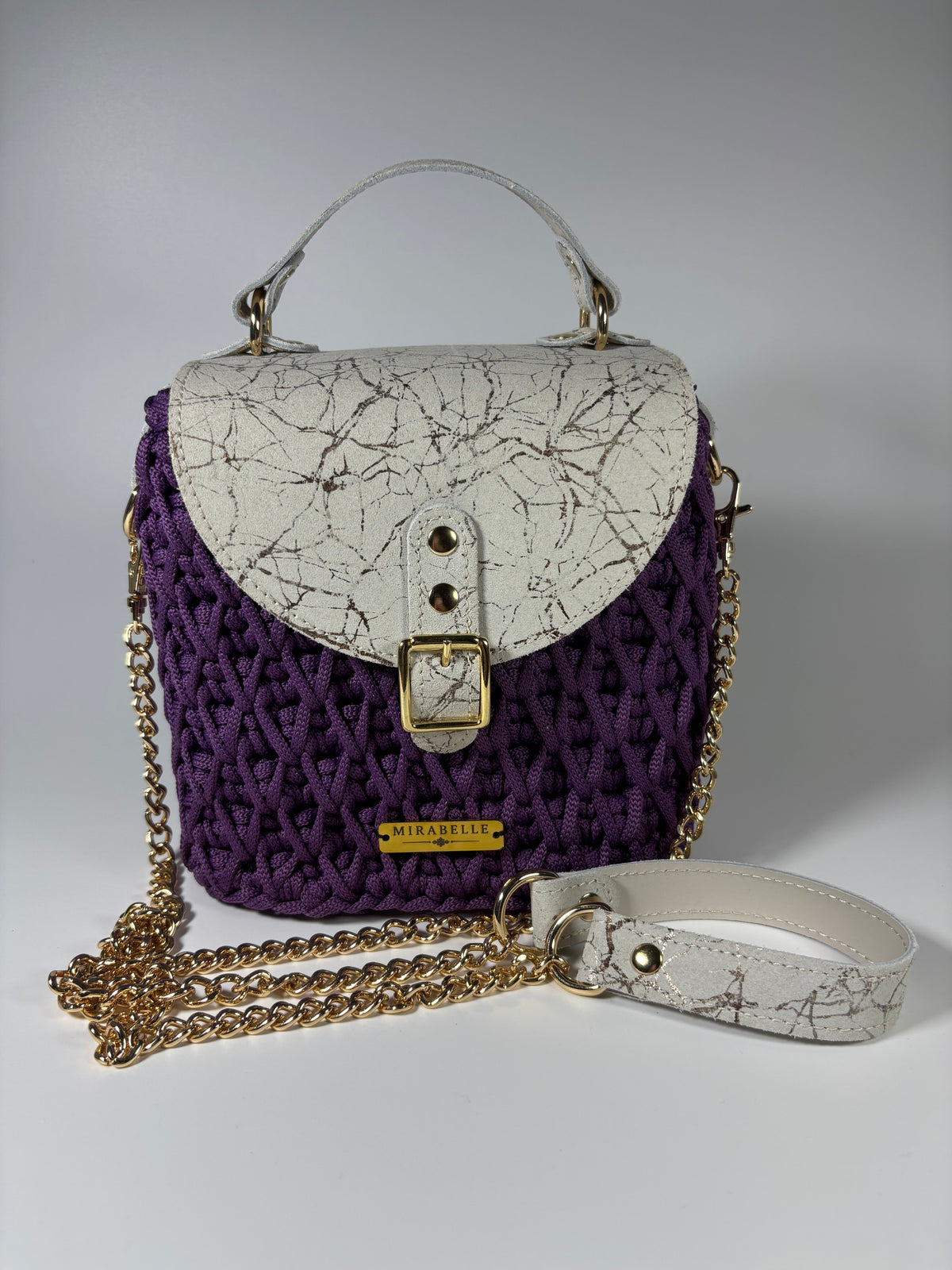 Sac violet avec sa bandoulière chaîne dorée et cuir blanc craquelé