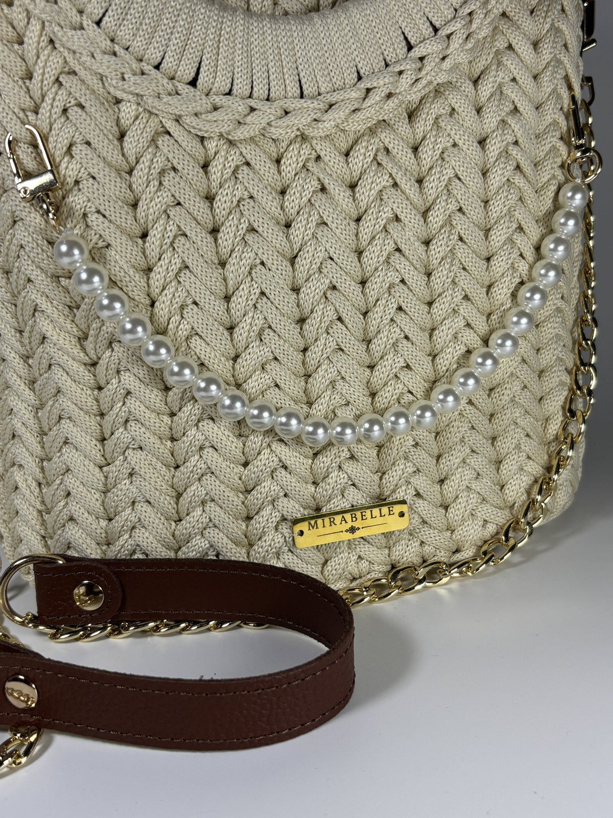 Détail des perles nacrées et de la plaque Mirabelle sur le crochet écru